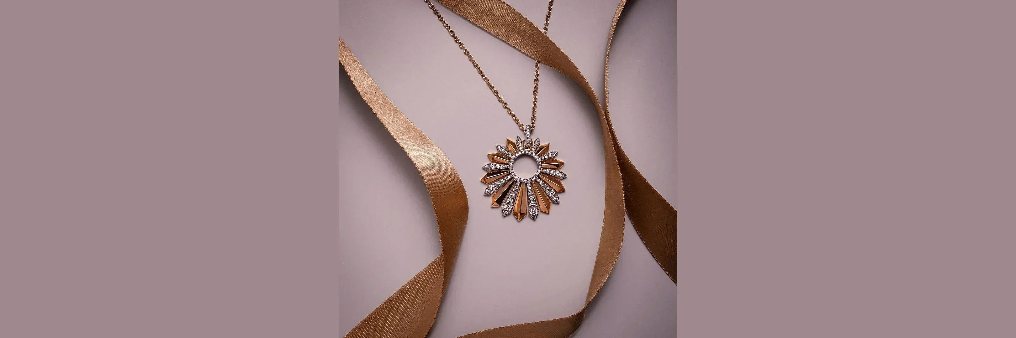 Gold sunburst pendant necklace with clear stones on chain, elegant jewelry for women