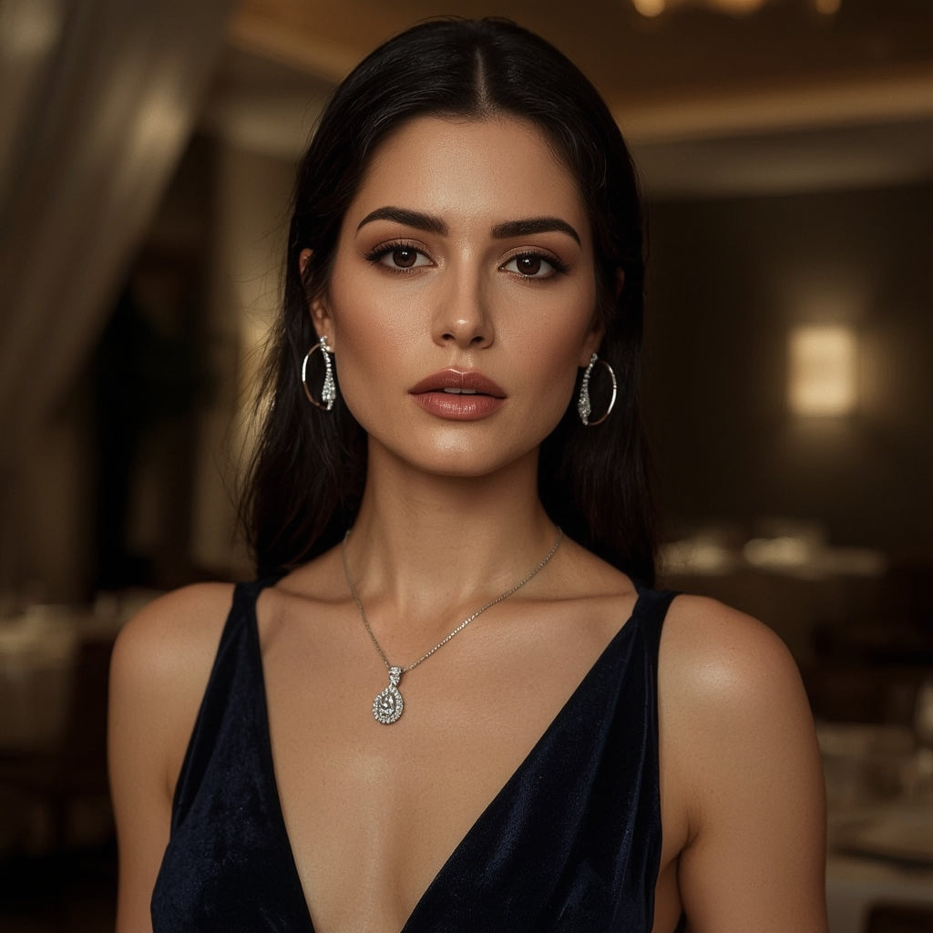Elegant woman wearing silver drop earrings and teardrop pendant necklace, evening setting