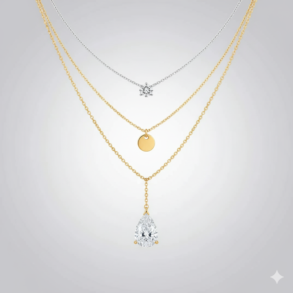 Layered gold and silver necklaces with round and teardrop pendants on a light background