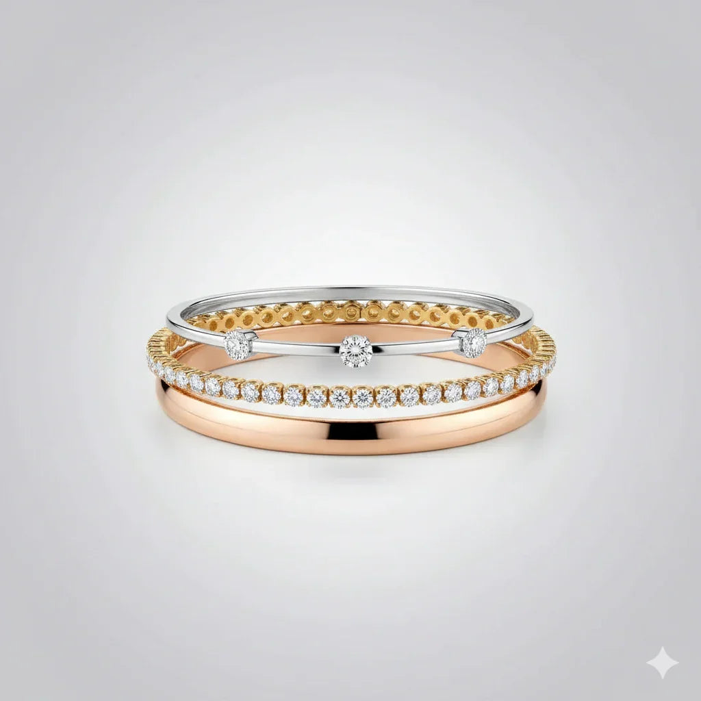 Stacked gold and silver rings, one with pavé diamonds, on a light background