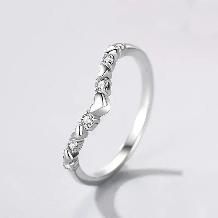 925 silver heart-shaped ring with clear gemstones on white background