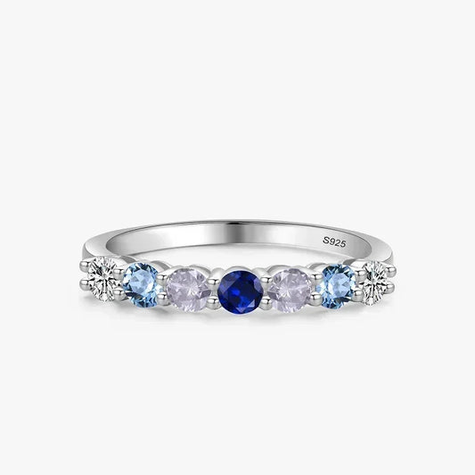 Silver ring with blue and purple gemstones on a white background