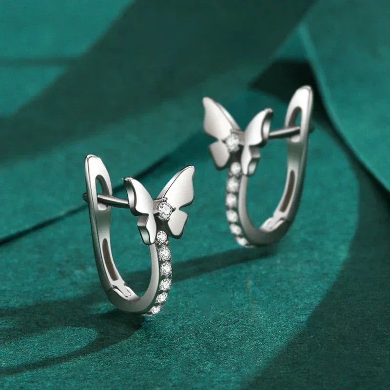 925 silver butterfly hoop earrings with sparkling cubic zirconia on green background