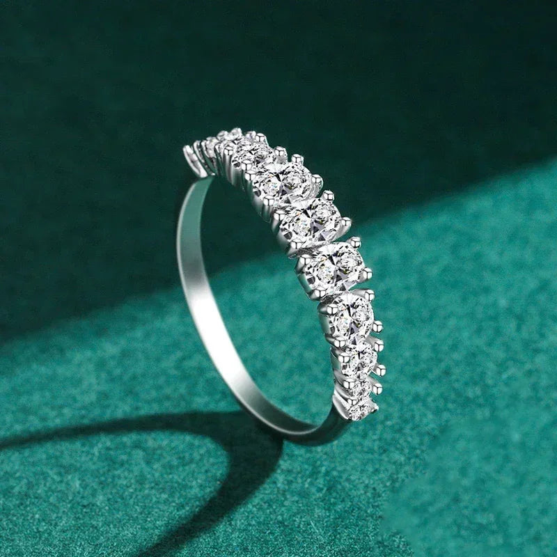 925 silver ring with row of sparkling round-cut white stones on green background