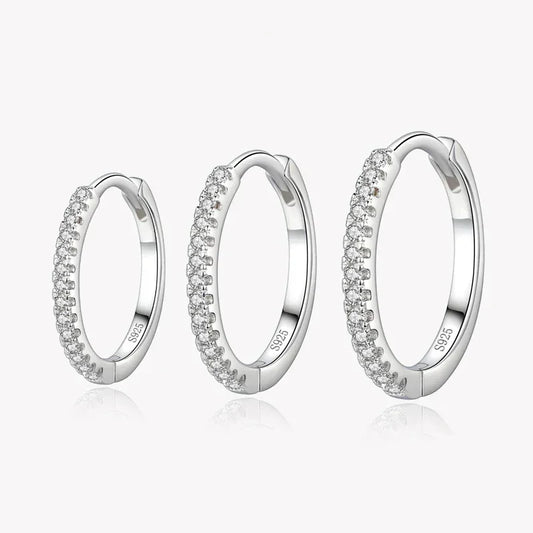 Three sterling silver hoop earrings with pavé cubic zirconia, displayed on a white background.