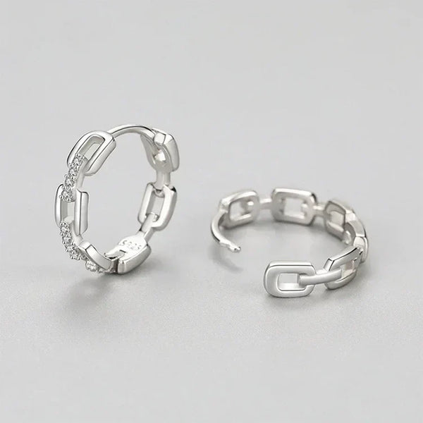 Pair of silver hoop earrings on a light gray background