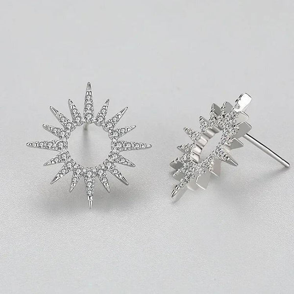 Pair of silver star-shaped earrings on a light gray background