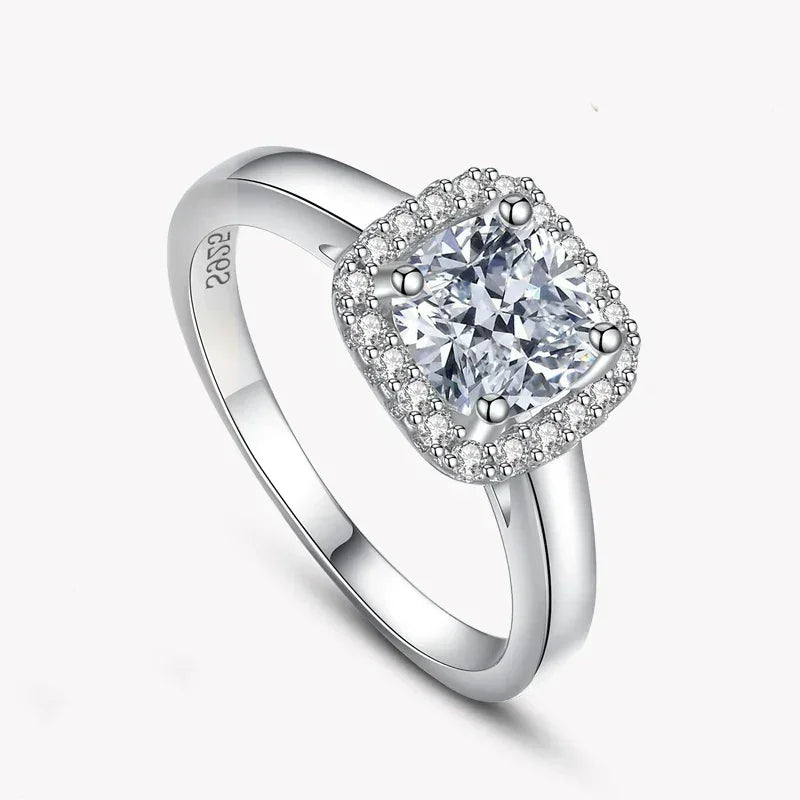 925 silver ring with cushion-cut center stone and halo of small gemstones on white background
