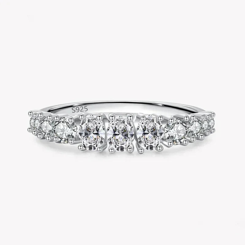 925 sterling silver ring with round white gemstones in a row on a plain background