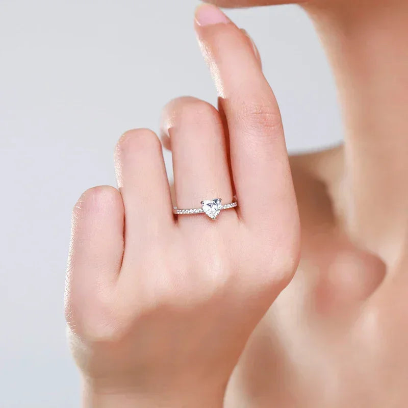 Woman wearing a silver heart-shaped diamond ring on her finger, elegant jewelry close-up