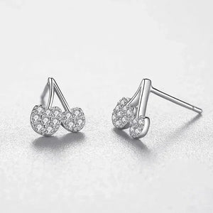 Pair of silver earrings with clear gemstones on a light gray background