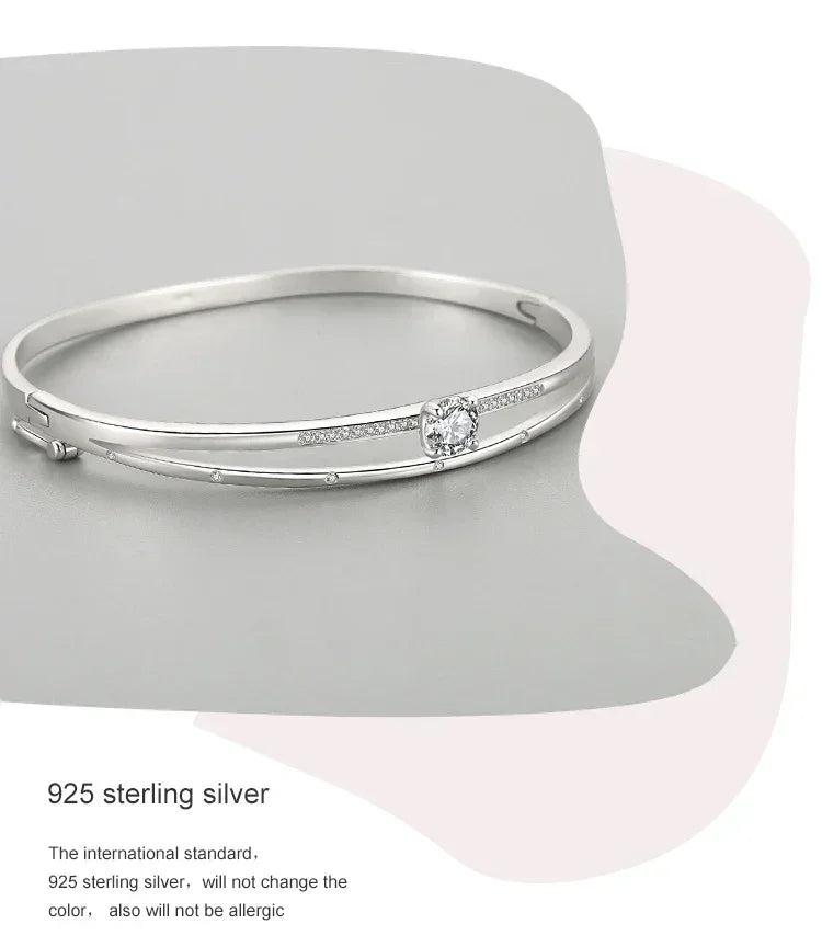 925 sterling silver bangle bracelet with central round cubic zirconia and delicate side stones