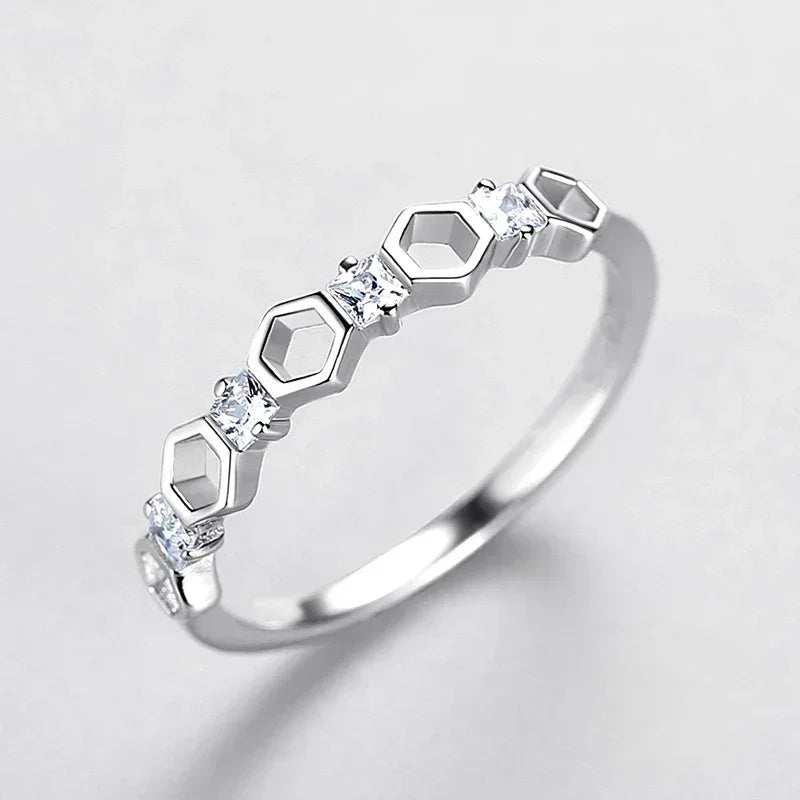 Sterling silver ring with geometric hexagon design and small clear stones on white background