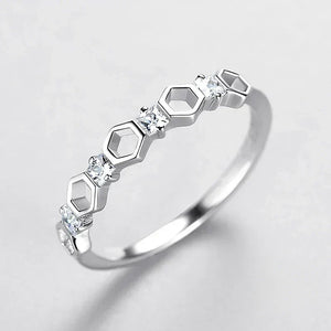 Sterling silver ring with geometric hexagon design and small clear stones on white background