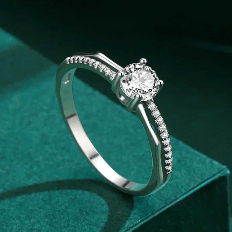 925 silver engagement ring with round solitaire and pavé accents on green backdrop