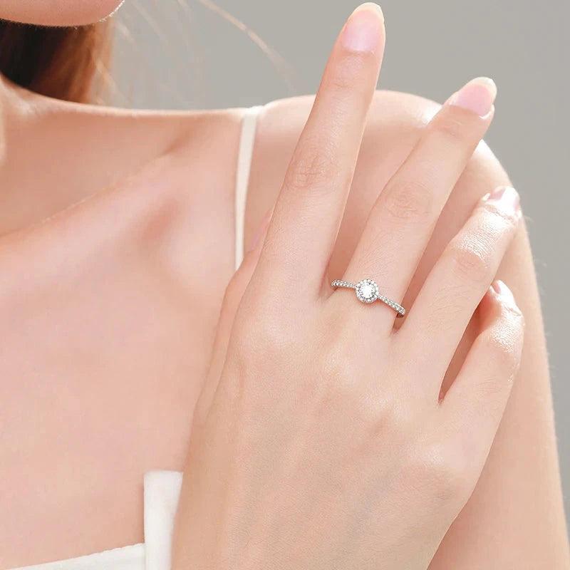 Elegant woman wearing a 925 silver solitaire ring with round clear gemstone