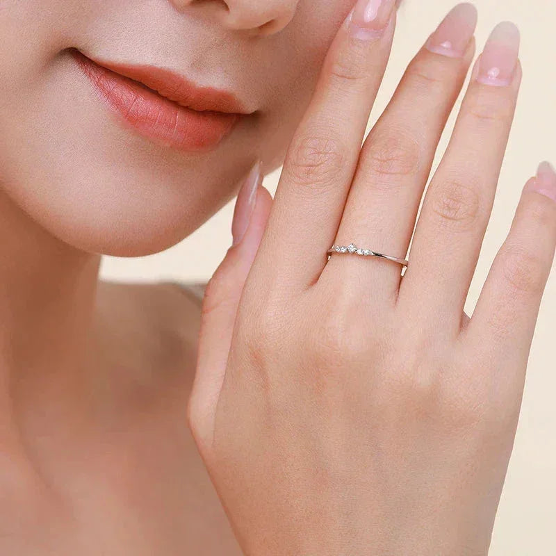 Woman wearing delicate 925 silver ring with small gemstones on finger, close-up