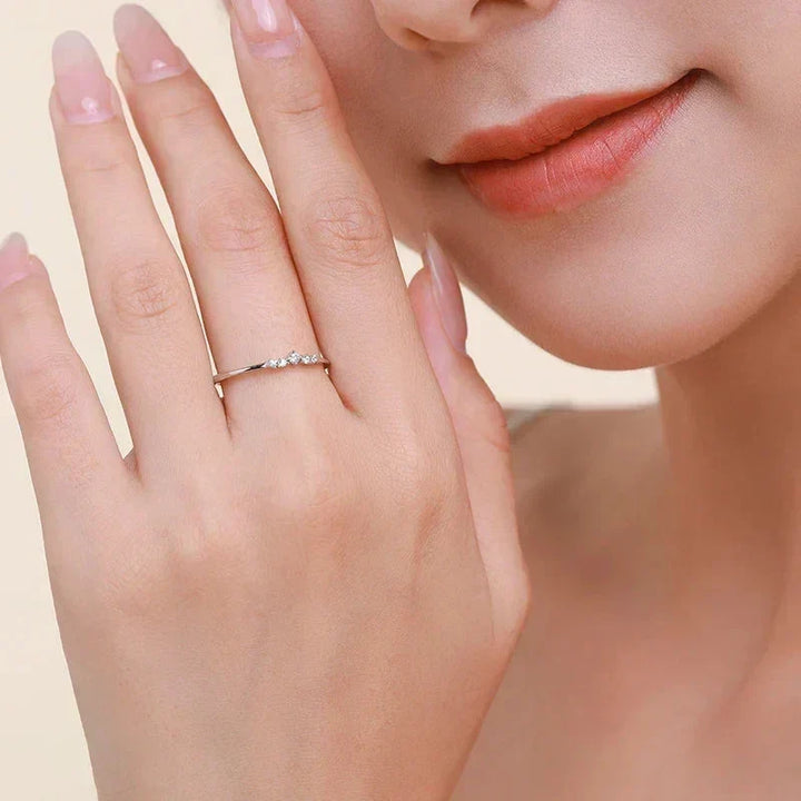 Close-up of a hand wearing a ring with a soft focus on the face.
