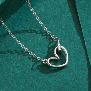 Silver heart-shaped necklace with a small diamond on a green background-Cherished Heart Pendant Necklace - TM & CO. JEWELS 