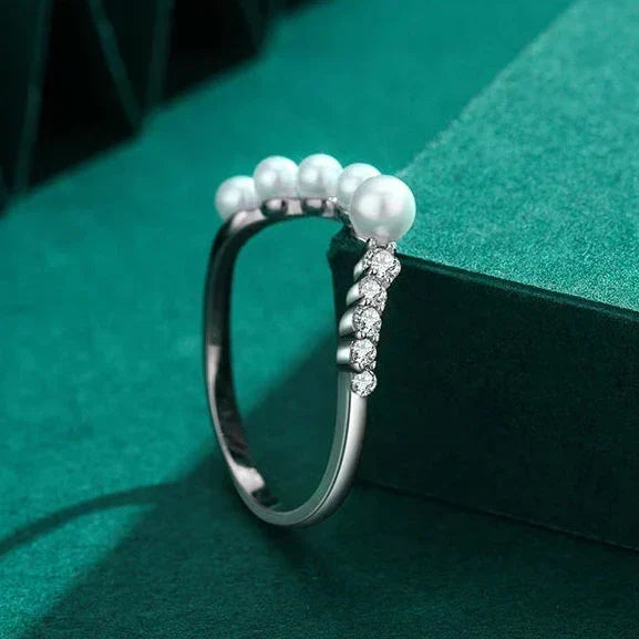 Silver ring with pearls on a green background