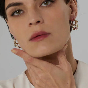 Woman wearing gold-plated drop earrings with crystals, elegant jewelry for women