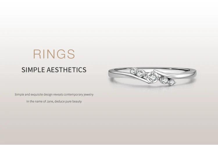 Minimalist silver ring with small sparkling gemstones on clean white background