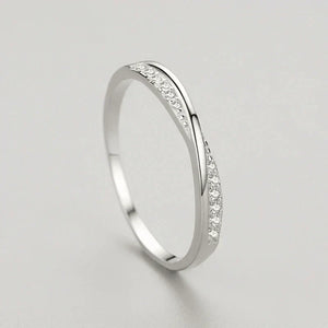 Sterling silver twisted band ring with small pavé cubic zirconia stones on a light background
