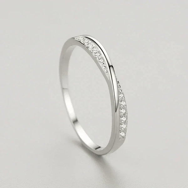 Sterling silver twisted band ring with small pavé cubic zirconia stones on a light background