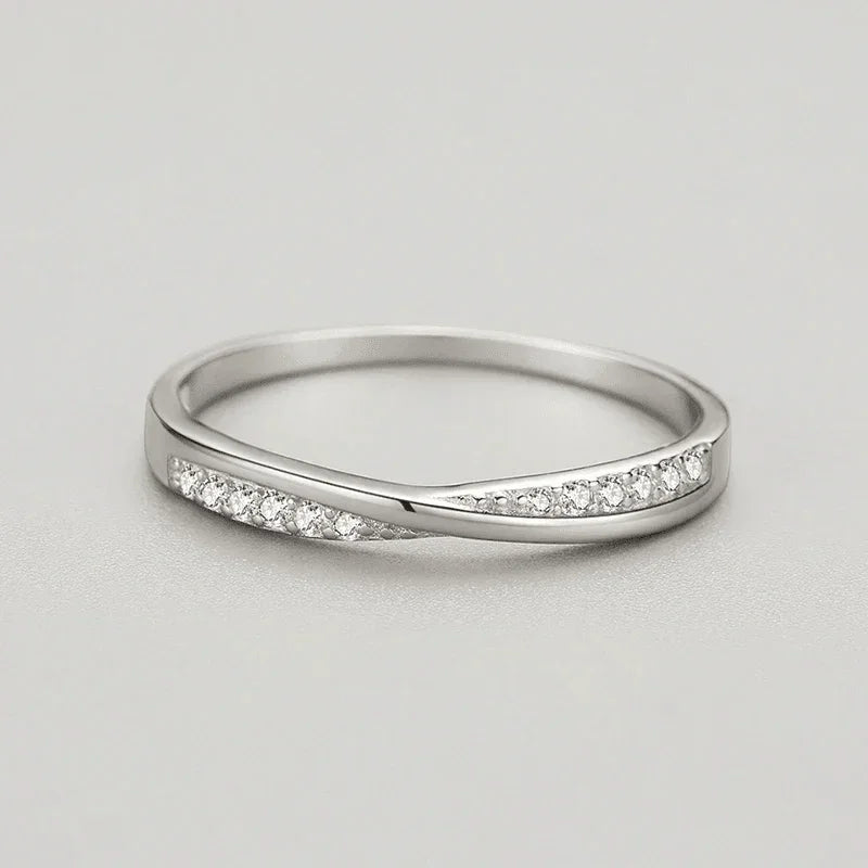 Sterling silver twisted band ring with small pavé cubic zirconia stones on a light background