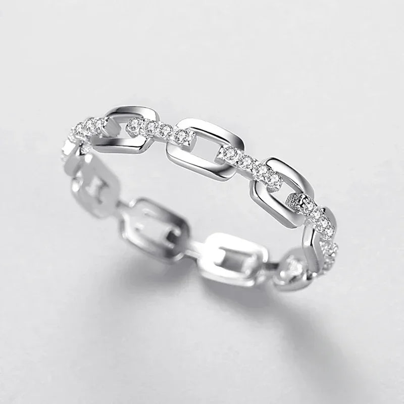 Sterling silver chain link ring with sparkling cubic zirconia stones on white background