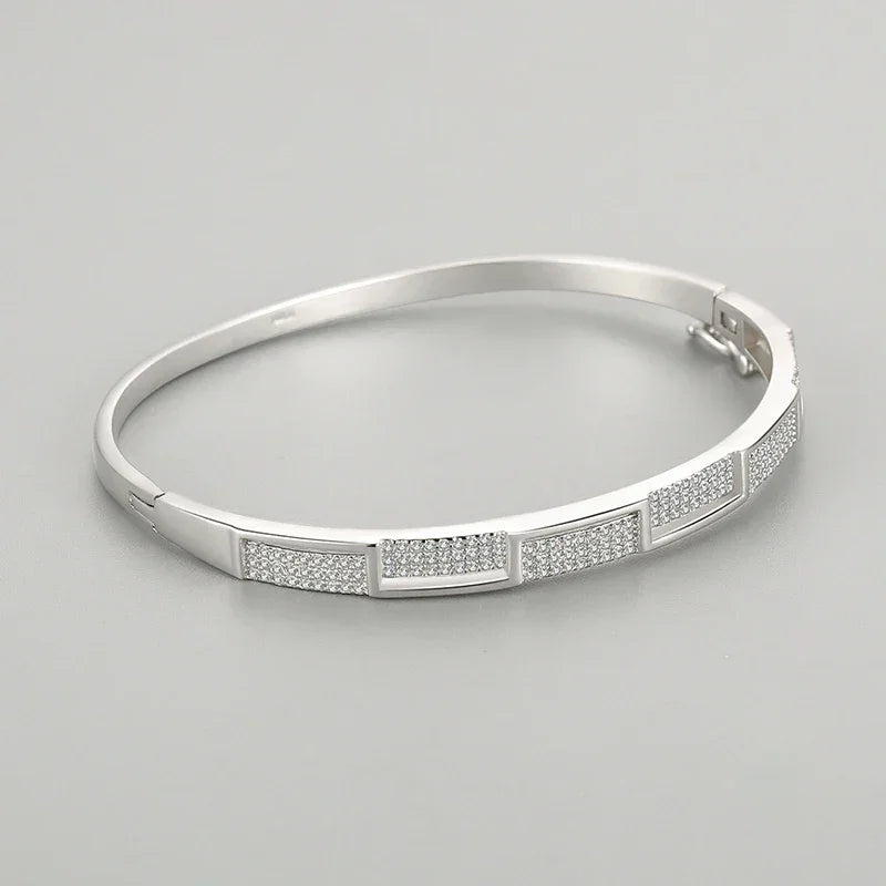 Elegant 925 silver bangle bracelet with rectangular pave-set crystal accents on gray background