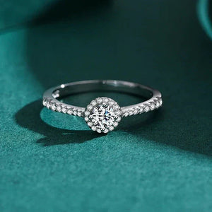 Sterling silver ring with round center cubic zirconia and pavé band on white background