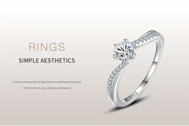 Sterling silver ring with round-cut solitaire and pave accent stones, elegant minimalist design.