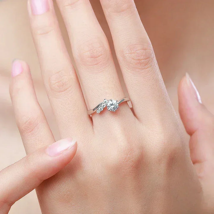 Elegant silver engagement ring with round-cut diamonds on woman's hand