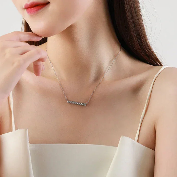 Woman wearing a delicate 925 silver bar necklace with baguette crystals