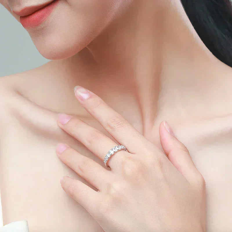 Woman wearing an elegant silver eternity band ring with clear stones on her finger