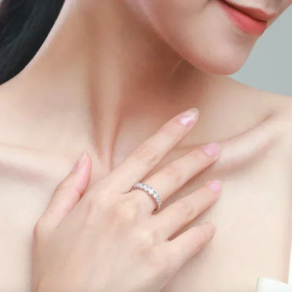 Woman wearing elegant 925 silver eternity band ring with sparkling gemstones on her finger