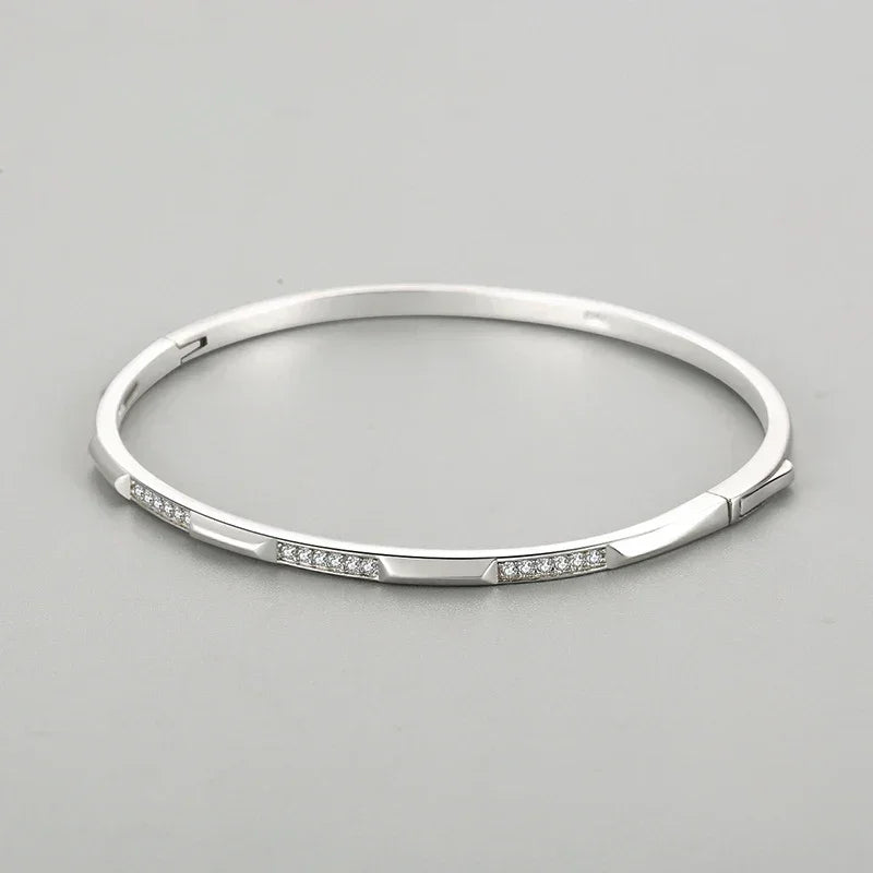 Sterling silver bangle bracelet with geometric segments and sparkling cubic zirconia accents