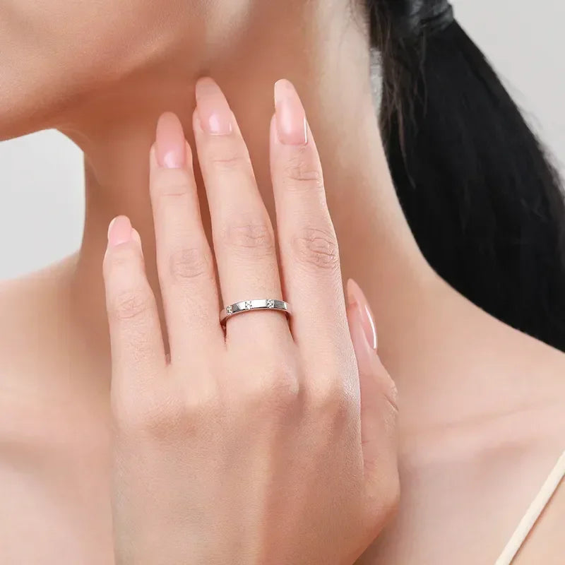 Woman wearing a silver band ring with small clear stones, elegant minimalist jewelry