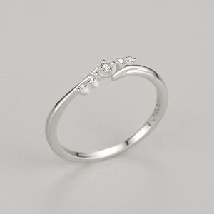 925 silver ring with small round white stones in minimalist setting on gray background