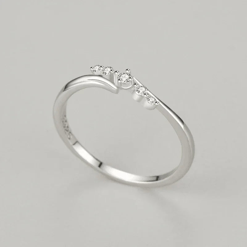 Sterling silver ring with five small round white stones on a minimalist band