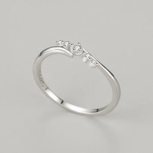Sterling silver ring with five small round white stones on a minimalist band