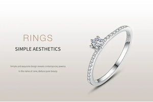 Elegant 925 silver ring with small diamonds and a central round gemstone on a minimalist background.