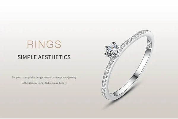 Elegant 925 silver ring with small diamonds and a central round gemstone on a minimalist background.