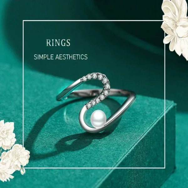 Silver ring with a pearl and small diamonds on a teal background
