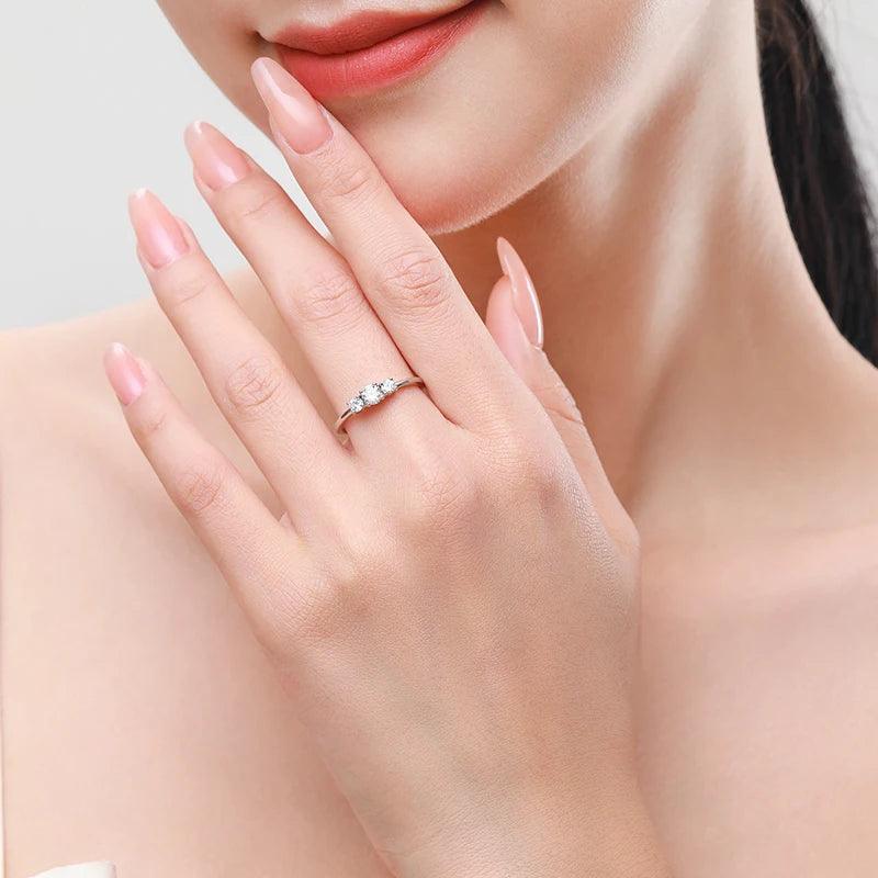 Woman wearing elegant 925 silver ring with three sparkling gemstones on her finger