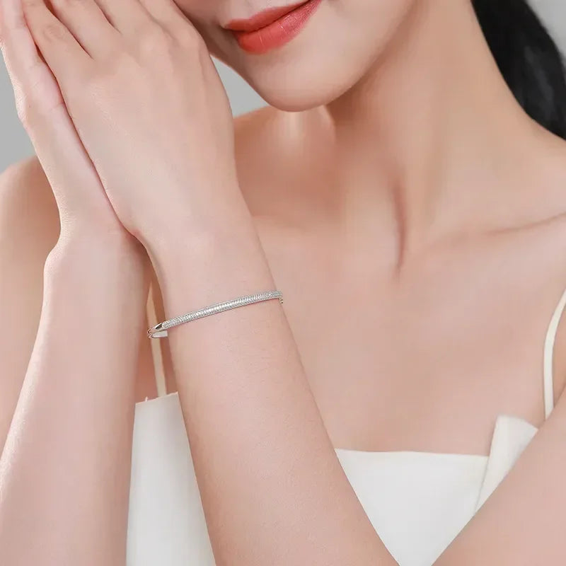 Woman wearing an elegant 925 silver bracelet on wrist, minimalistic jewelry style.