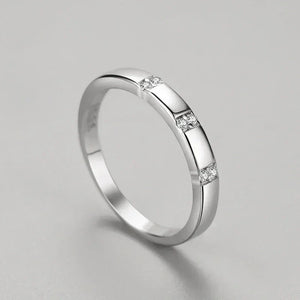Silver ring with small diamonds on a gray background