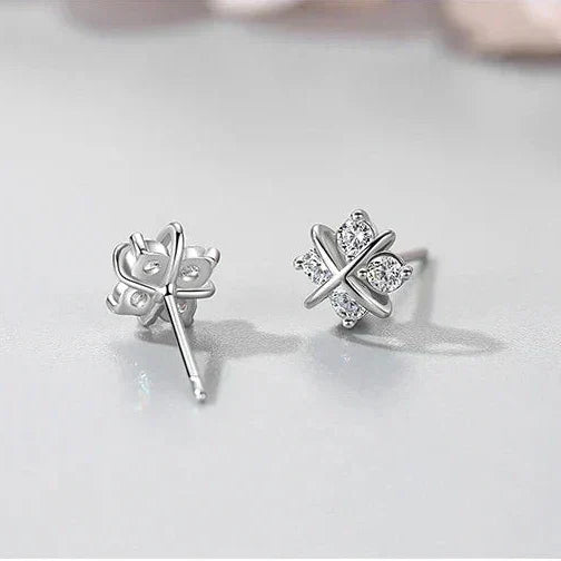 Pair of silver earrings with a star design on a light gray background