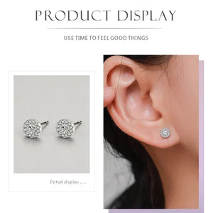 Silver stud earrings displayed on an ear and in detail on a gray background.